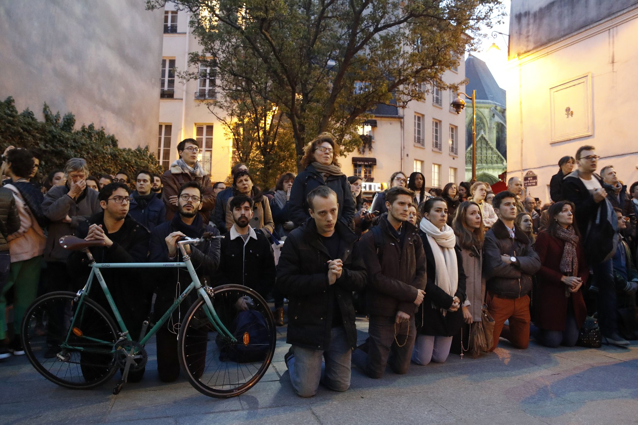 news image of people praying on the street of Paris